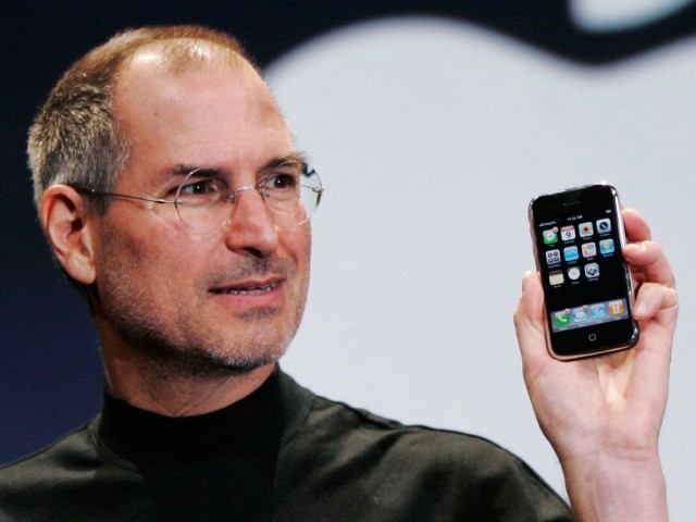 Late Apple CEO Steve Jobs holds up the first iPhone in 2007
